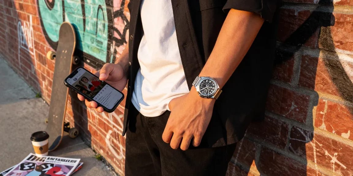 Fashionable individual showcasing clone watches in an urban setting with sunlight highlighting the watch's details.