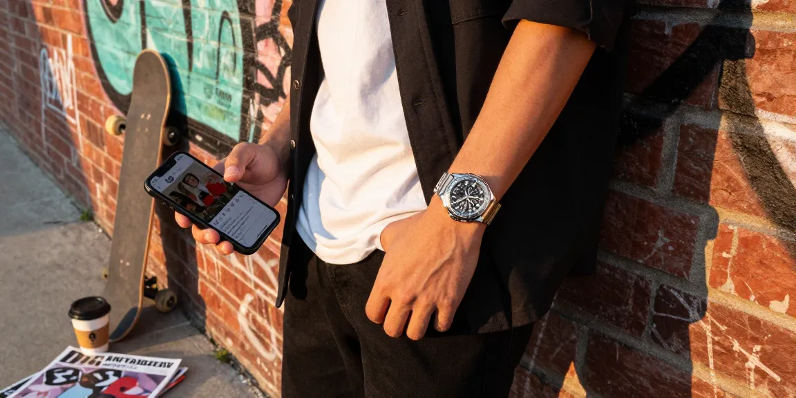 Fashionable individual showcasing clone watches in an urban setting with sunlight highlighting the watch's details.